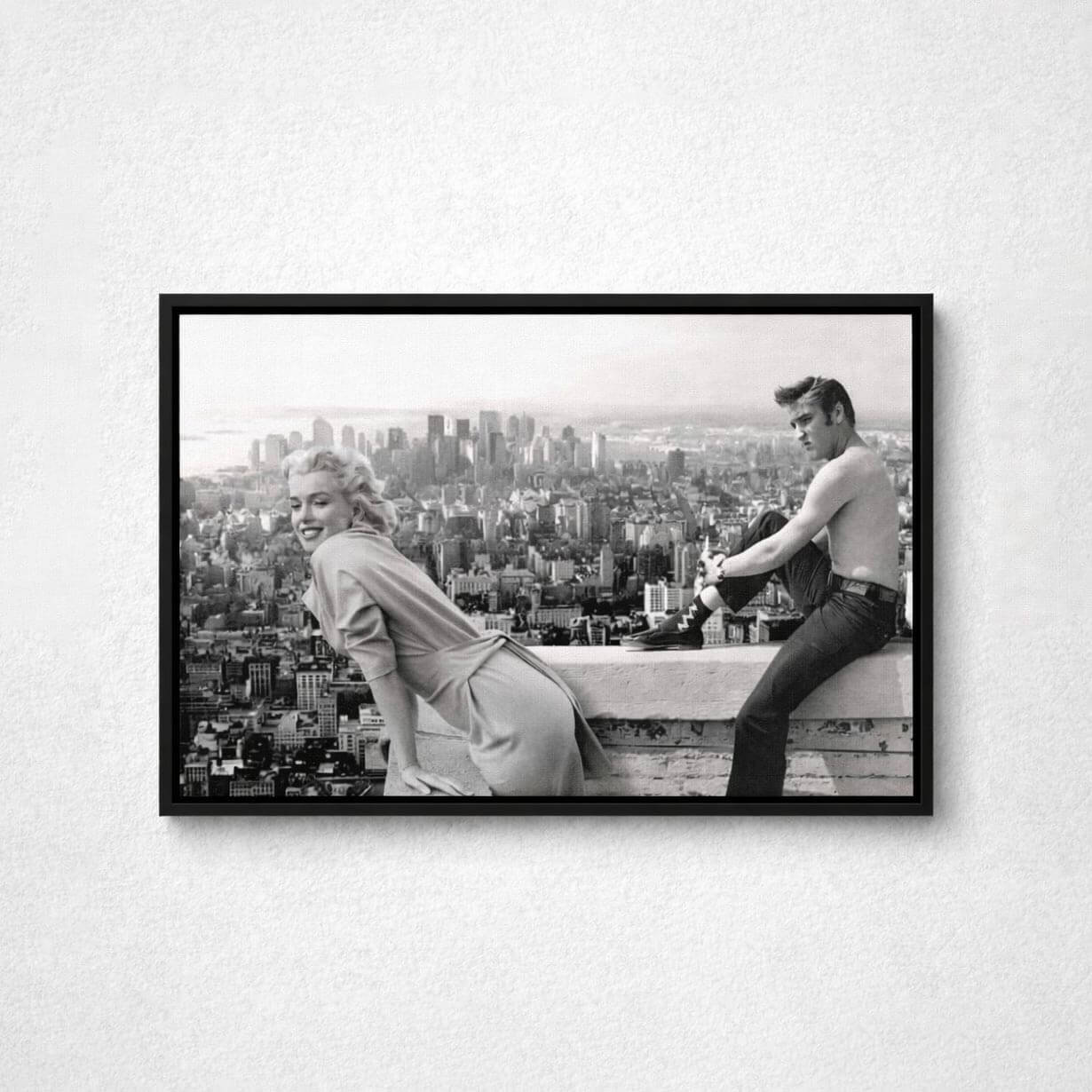 Framed black and white photo of a couple on a rooftop with a cityscape view.